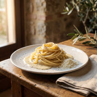 Ein Teller Spaghetti in cremiger heller Käsesauce mit grob gemahlenem Pfeffer