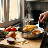 Ein goldbraun überbackenes Schinken-Käse-Sandwich in der Pfanne, aufgeschnitten mit zerlaufendem Käse, daneben ein Glas Joes Honig Senf