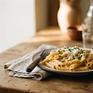 Penne in einer cremigen orangen Paprika-Sahne-Sauce mit frischen Kräutern