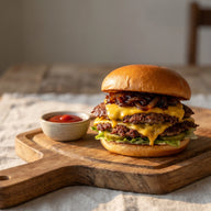 Zwei Smash Burger mit krosser Kruste, geschmolzenem Käse und glänzenden Zwiebeln auf einem Brett