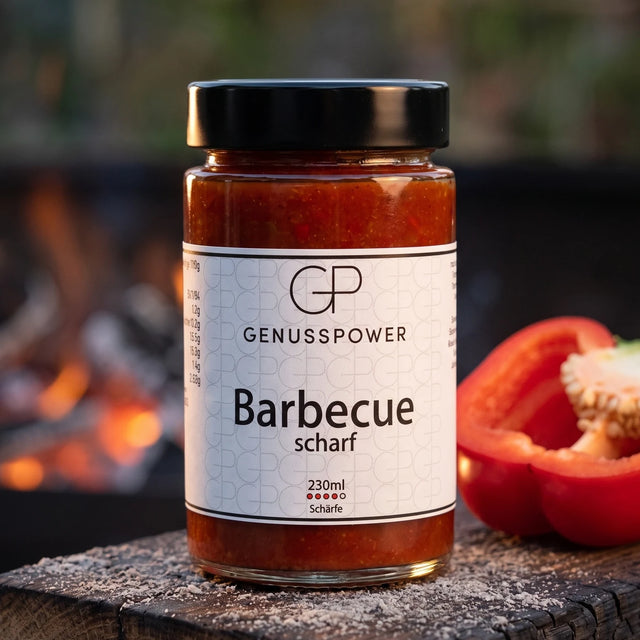 Barbecue scharf Grillsauce im Glas auf verkohlter Eiche, daneben eine halbe rote Paprika