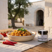 Orecchiette mit rotem Pesto in einer Terrakottaschale im Hof einer Masseria in Apulien, daneben Pesto Peperoncino von Genusspower