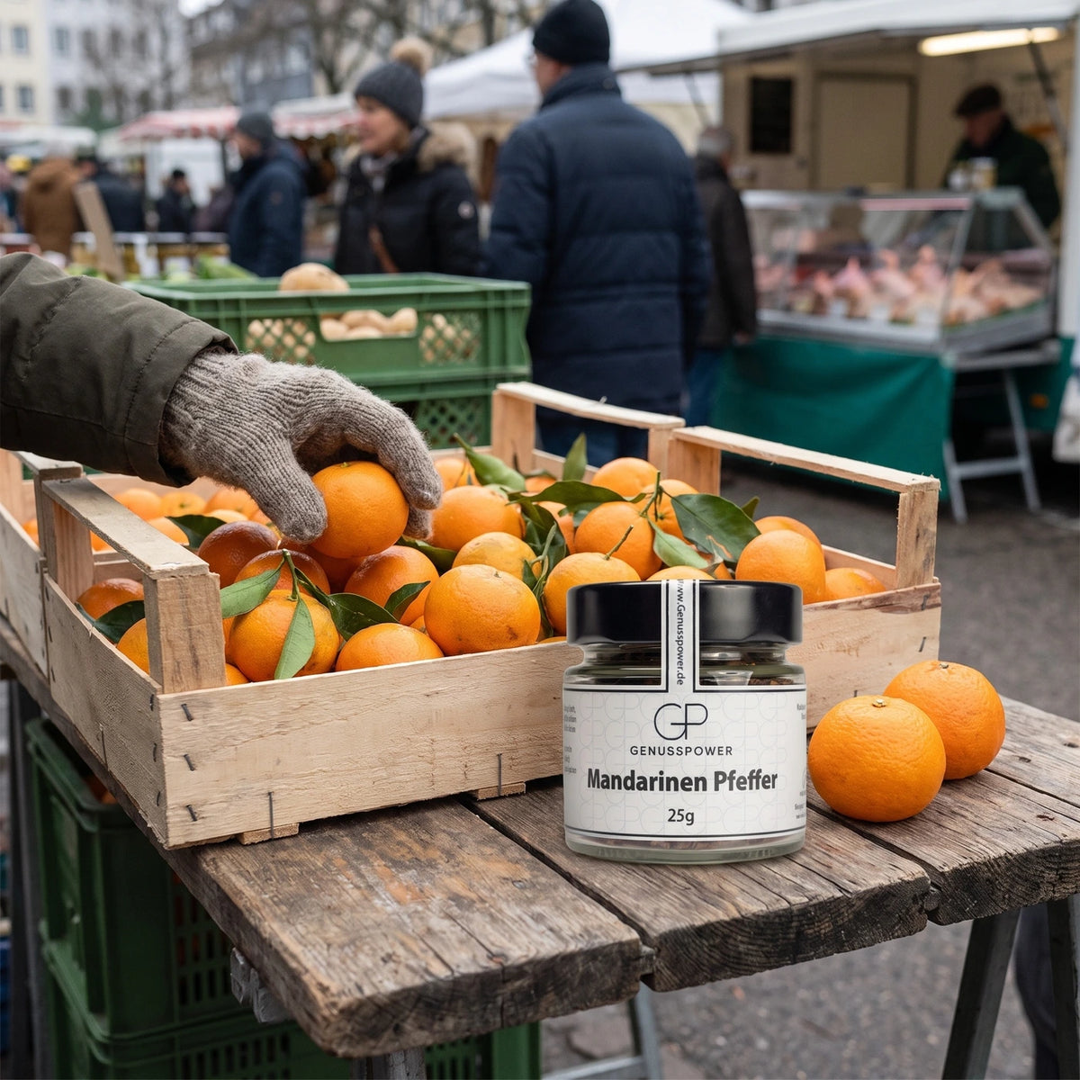 Glas Mandarinen Pfeffer von Genusspower am Wintermarkt neben einer Kiste frischer Mandarinen