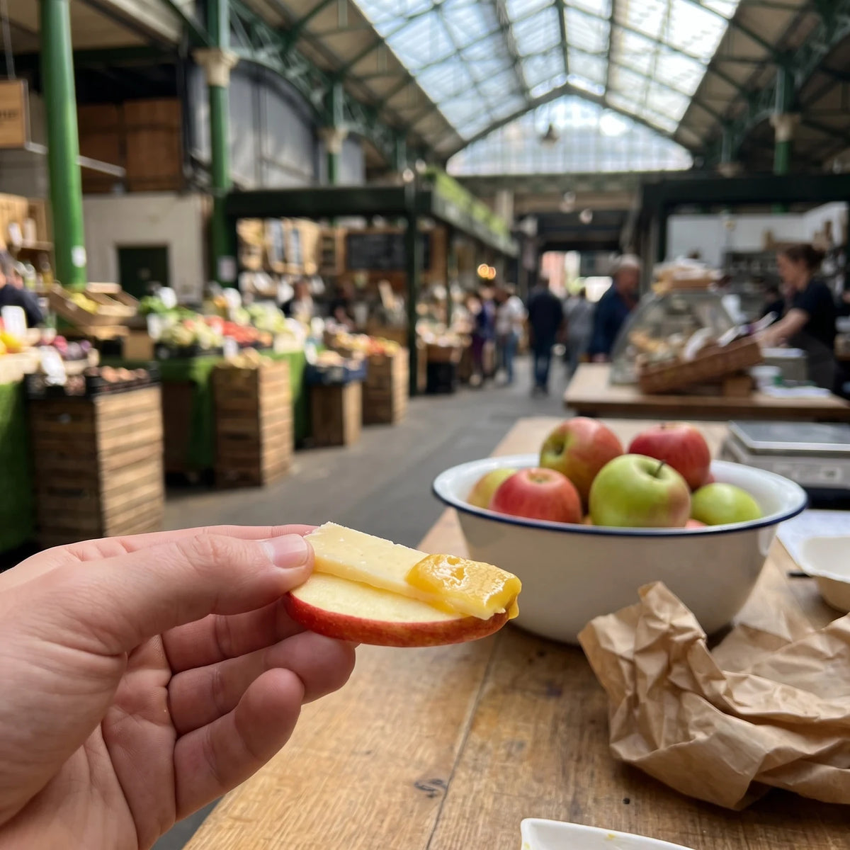 Hand hält eine Apfelscheibe mit Käse und Apfel-Calvados Senf