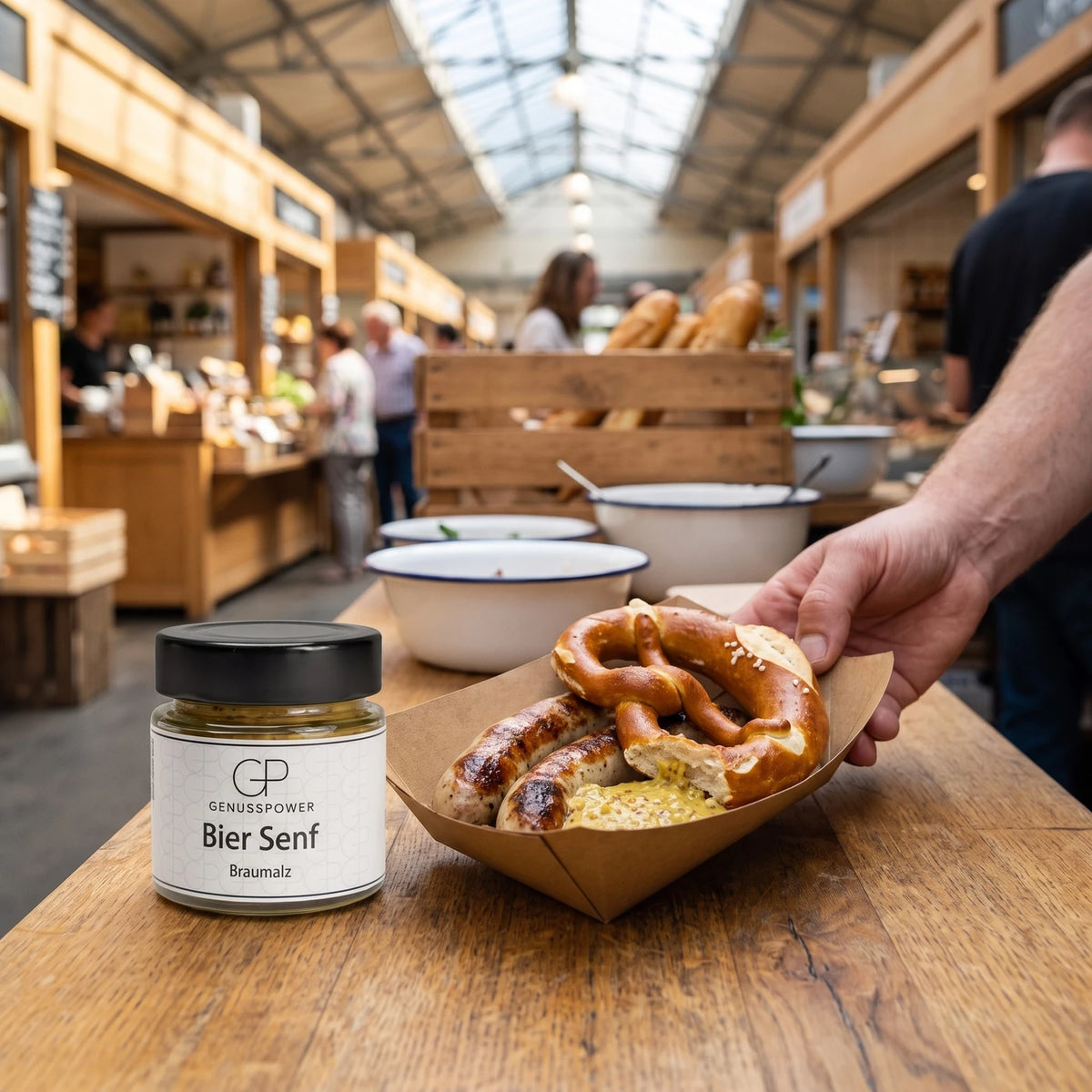 Hand stellt eine Schale mit Bratwurst und Brezel auf die Theke, dahinter das Glas Bier Senf Braumalz