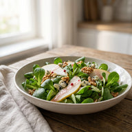 Feldsalat mit Birnenspalten, Walnüssen und Blauschimmelkäse in einer flachen Schale