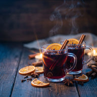 Dampfende Gläser Glühwein mit Orangenscheibe, Zimtstangen und Sternanis
