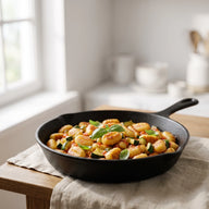 Goldbraun gebratene Gnocchi mit Zucchini und Tomatensauce in einer Pfanne
