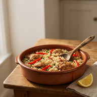 Hähnchen mit Reis, Paprika und Erbsen in einem weiten Topf