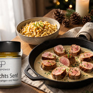 Rosa gebratene Schweinemedaillons in heller cremiger Senfsauce in einer Pfanne, mit Schnittlauch bestreut