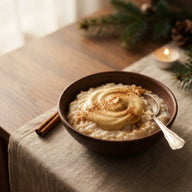 Schale mit cremigem Milchreis, obendrauf helle Zimtschnecken Creme und Zimt, daneben eine Zimtstange