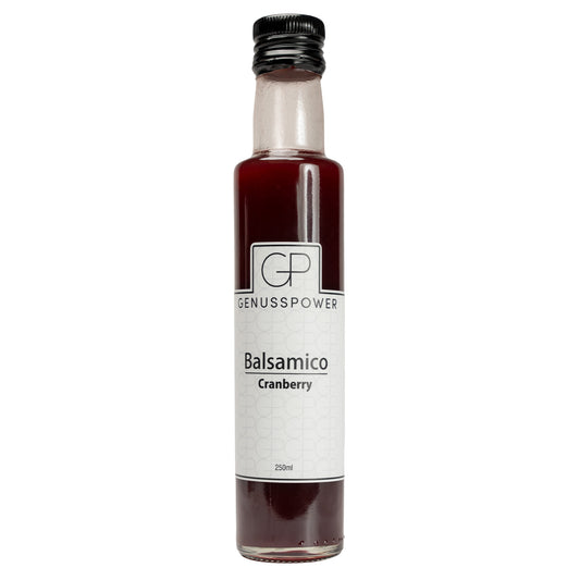 Schlanke Glasflasche Balsamico Cranberry von GenussPower mit 250 ml, tiefroter Inhalt, cremefarbenes Etikett und schwarzer Verschluss