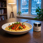 Couscous mit Ofengemüse in einer Keramikschale am Esstisch an einem Winterabend, daneben Harissa von Genusspower