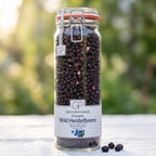 Großes Bügelglas gefriergetrocknete Wild-Heidelbeeren von Genusspower auf einem weißen Gartentisch im Morgenlicht