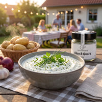 Kräuterquark mit Pellkartoffeln in einer Steingutschale bei einer Gartenparty, daneben Käse & Quark von Genusspower