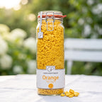 Großes Bügelglas gefriergetrocknete Orange von Genusspower auf einem weißen Gartentisch im Morgenlicht