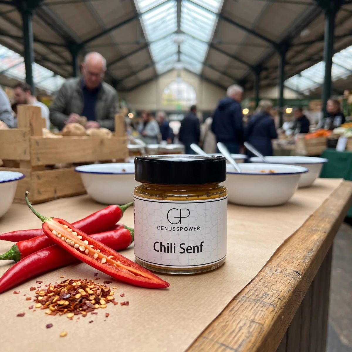 Glas Chili Senf von Genusspower auf der Markttheke, daneben rote Chilis